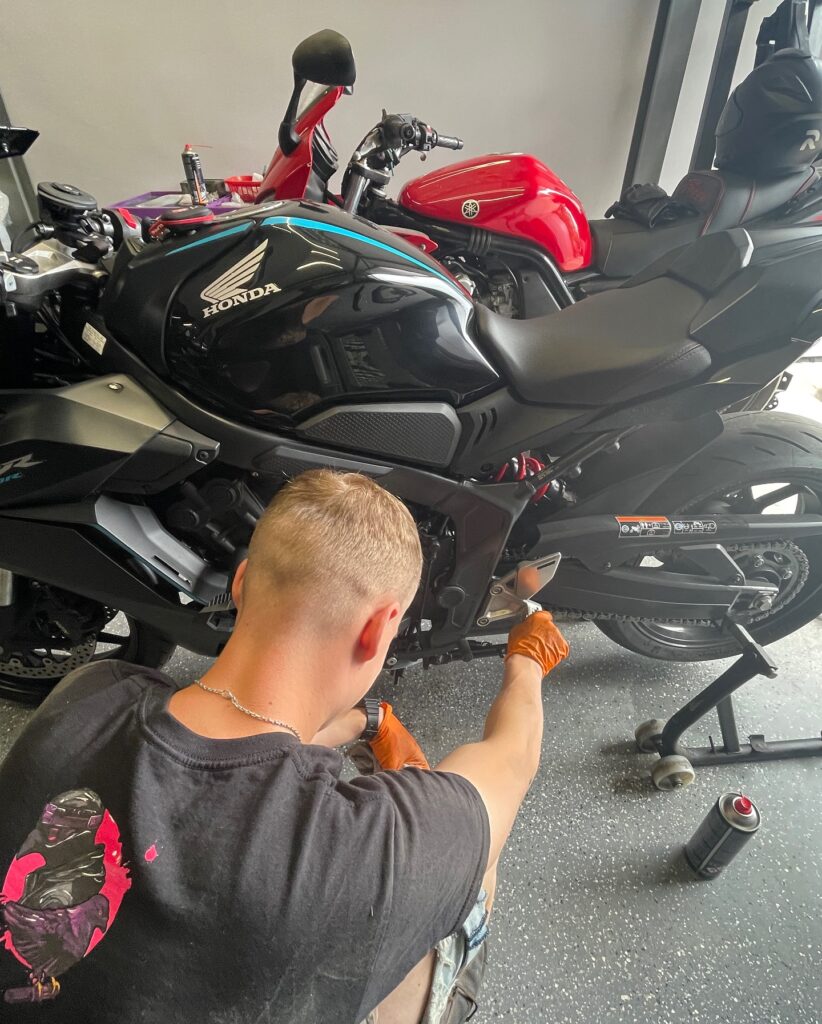 Mechanik wykonuje przegląd okresowy motocykla Honda CBR650 – kontrola i regulacja elementów napędu w warsztacie PGEN-MOTO.